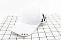 Detalle de gorra blanca de algodón con bordado M negro y tres anillas metálicas plateadas - Niños / Blanco