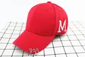 Detalle de gorra de béisbol roja con bordado M blanco y tres anillos metálicos plateados - Niños / Rojo