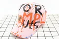 Detailed top view of pink graffiti baseball cap featuring vibrant orange ink splatter art - Kids / MPL Pink