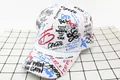 Detailed top view of white cotton baseball cap with colorful graffiti print and mottos - Kids / FD White