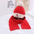 Close-up of strawberry embroidery and fluffy white pom-pom on red knitted kids hat - Kids approx 3-10 years / Red