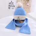 Close-up of children's blue knit hat and scarf set with avocado embroidery and pom-poms - Kids approx 3-10 years / Blue
