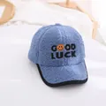 Detailed macro view of the blue lamb wool baseball cap with GOOD LUCK embroidery and smile - Kids / Blue