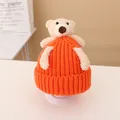 Orange knitted baby beanie with a cute beige teddy bear doll and soft wool texture - Hat / Orange