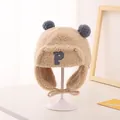 Detailed view of beige fleece trapper hat with blue pom-poms and P letter patch for kids - Khaki