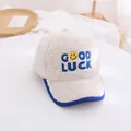 Close-up of beige fleece baseball cap with Good Luck embroidery and blue contrast brim - Kids / White