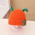 Kids orange knit beanie featuring green dinosaur horns and a cute woven label detail - Beanie / Orange