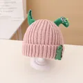 Pink chunky knit kids beanie with green plush dinosaur horns and tail decoration - Beanie / Pink