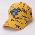 Dettaglio del cappellino giallo per bambini in cotone con graffiti e toppa logo rotonda - Bambini (circa 3-10 anni) / Giallo
