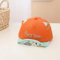 Detail of baby baseball cap featuring orange crown, blue ears, and cute cartoon cat brim - Infant 0-30 Months / Orange