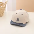 Dettaglio del cappellino da neonato beige e blu con visiera morbida e lettera R ricamata - Neonato / Tesa Grigia