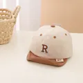 Close-up of baby baseball cap featuring soft brim and embroidered letter R patch - Baby / Light Coffee Brim