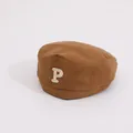Détail d'un béret vintage en toile marron avec logo brodé de la lettre P blanche - Enfant / café