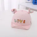 Detailed view of pink corduroy baby cap with LOVE embroidery and 3D dolphin accent - Pink