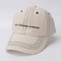 Detailansicht der cremefarbenen Baumwollkappe mit schwarzen Kontrastnähten und Stickerei - Kinder (2-8 Jahre alt) / Beige-HELLO Stickerei Stil