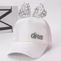 Détail de la casquette en satin blanc pour filles avec gros nœud argenté et logo en strass - Enfants (environ 3-8 ans) / Blanc