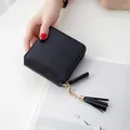 Women's black square zip-around wallet with gold tassel detail in a portable handheld view - Black