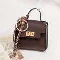 Dark brown pebble leather mini bag pendant with gold hardware and colorful lanyard charm - Coffee