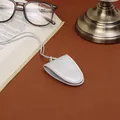 Magnetic light gray leather eyewear clip with lanyard on a leather desk background - Silver