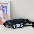 Kids chest bag in black and green contrast with 1986 number print and adjustable strap - Green