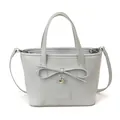 Bolso tote azul claro con lazo decorativo y colgante de corazón sobre fondo blanco - Azul