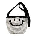 Minimalist hand-woven bucket bag with black smile face design and contrasting shoulder strap - White