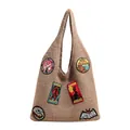 Brown knit tote bag featuring colorful embroidered mystery creature badges and top handle - Khaki