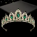 Macro view of golden bridal tiara with emerald green stones and sparkling rhinestones - Hg-056 Gold + Green