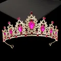 Close-up of golden crown featuring large teardrop rose red rhinestones and white crystals - Hg-056 Gold + Plum Red