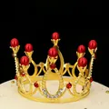 Golden crown cake topper with red pearls and crystals on a white base background - Gold + Red