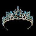 Macro view of gold baroque bridal crown with blue rhinestones on black background - Gold With Lake Blue