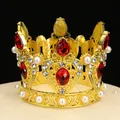 Macro shot of gold crown cake topper with red rhinestones and pearls on black backdrop - Gold+Red