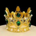 Detailed close-up of golden vintage crown with green gemstones and pearls on display - Gold + Green