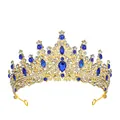 Detailed close-up of golden crown featuring blue teardrop gemstones and white crystals - Gold Tone + Royal Blue