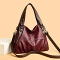 Detail view of burgundy lychee-grain faux leather bag with contrast stitching and pleats - Burgundy