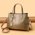 Modische beige Handtasche mit Kroko-Prägung und goldenem Metallanhänger-Detail - Khaki