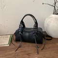 Borsa a tracolla Boston in pelle nera con occhielli argentati e lunghe nappe decor - Nero