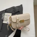 Minimalist beige crossbody bag with gold buckle and tassel detail for women - Soy White