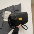 Minimalist black leather crossbody bag with a vintage gold metal lock and woven detail - Black