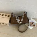 Borsa a mezzaluna marrone scuro minimalista con catena argentata e finitura in pelle - Marrone Tè