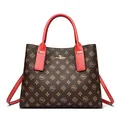 Brown monogram tote bag with vibrant red handles and kangaroo gold emblem detail - Burgundy