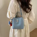 Light blue vintage bucket bag with teddy bear charm and metal clasp on shoulder strap - Blue