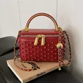 Elegant red vanity box bag with pearl texture and gold handle for crossbody wear - Burgundy