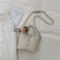 Minimalist beige bucket bag with lychee grain leather and cute bear charm accessory - With Pendant / Off White