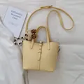 Minimalist yellow lychee grain leather bucket bag with a cute plush bear pendant - With Pendant / Yellow