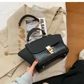 Detailansicht der schwarzen Tasche mit matter Klappe und Krokodilleder-Prägung für Damen - Schwarz