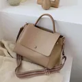 Minimalistische khakifarbene Lederhandtasche mit gewebtem Gurt in der Seitenansicht - Khaki