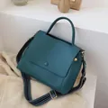 Minimalistische dunkelgrüne Handtasche mit geometrischem Webgurt und Goldbeschlägen - Blau