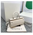 Minimalist beige cylindrical handbag in faux leather featuring a silver swivel lock clasp - White
