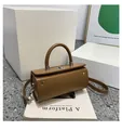 Chic brown cylinder shoulder bag with silver lock and detachable strap on white stand - Khaki